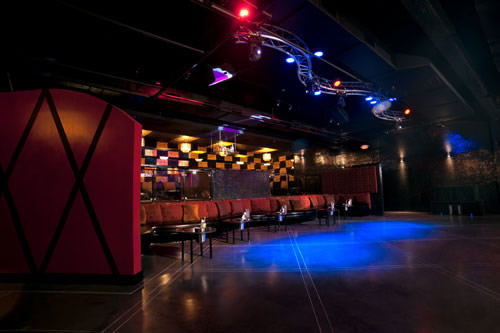 Moving-head lighting fixtures installed above the stage at 5th Amendment bar in Houston